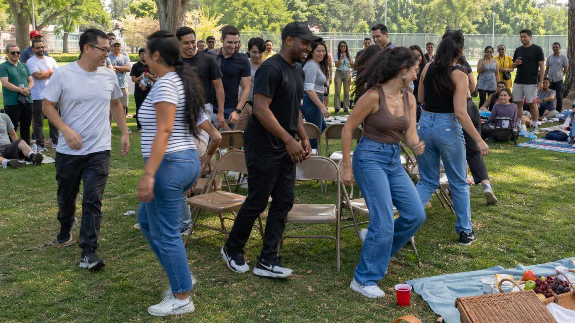 Large group playing musical chairs during a fun outdoor picnic event