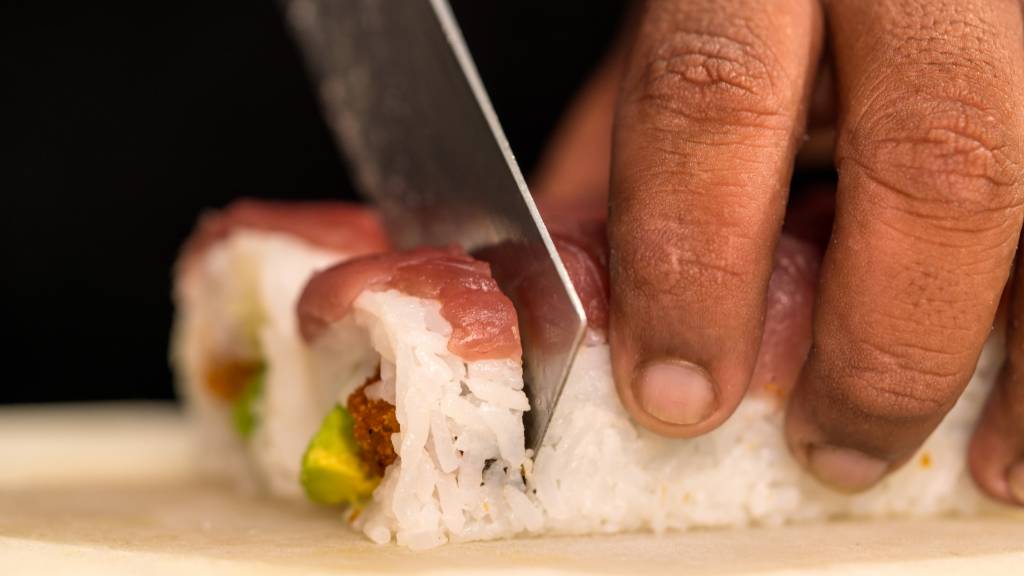 Chef slicing sushi rolls for food theme ideas