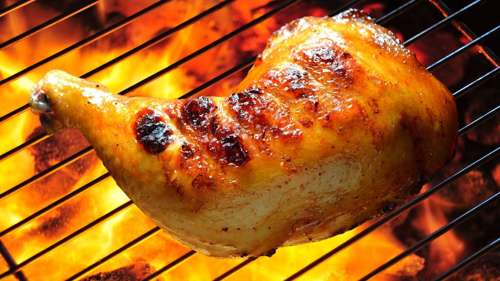 Grilled chicken leg over open flame for food theme ideas