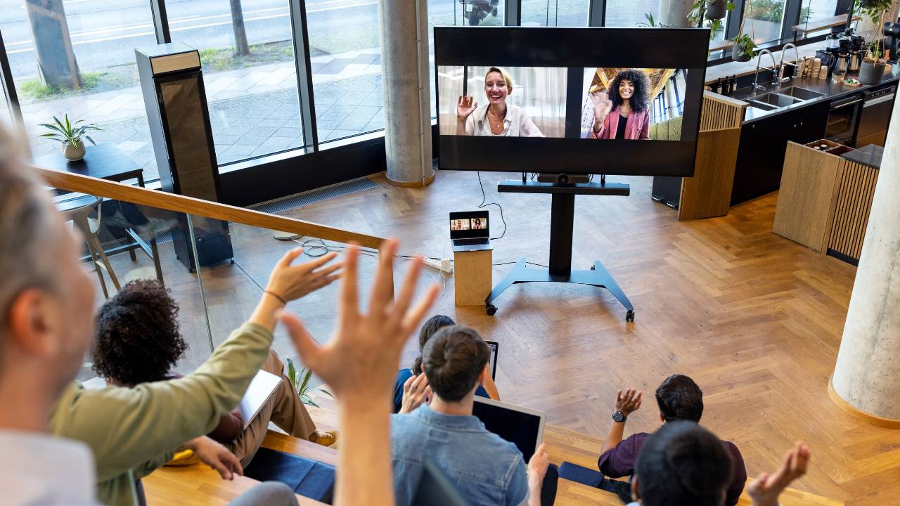 hybrid-events-meeting-virtual-participants people attending a hybrid meeting with virtual participants on screen