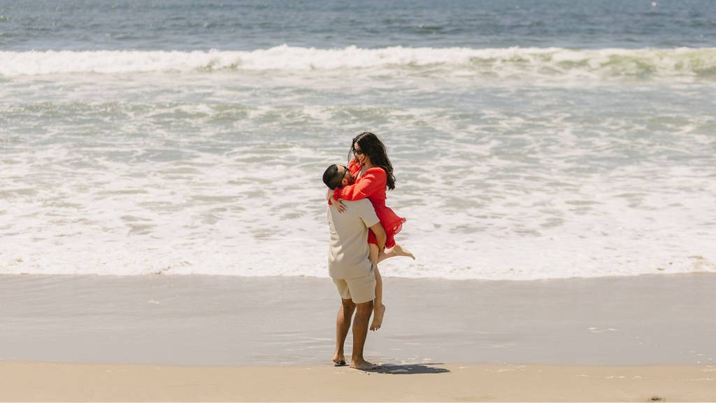 couple lifting pose beach picnic