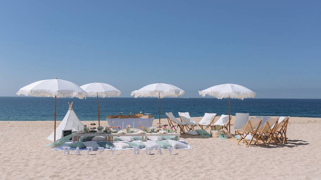 luxury beach picnic setup with umbrellas