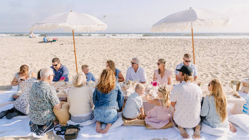 large family picnic photoshoot on the beach